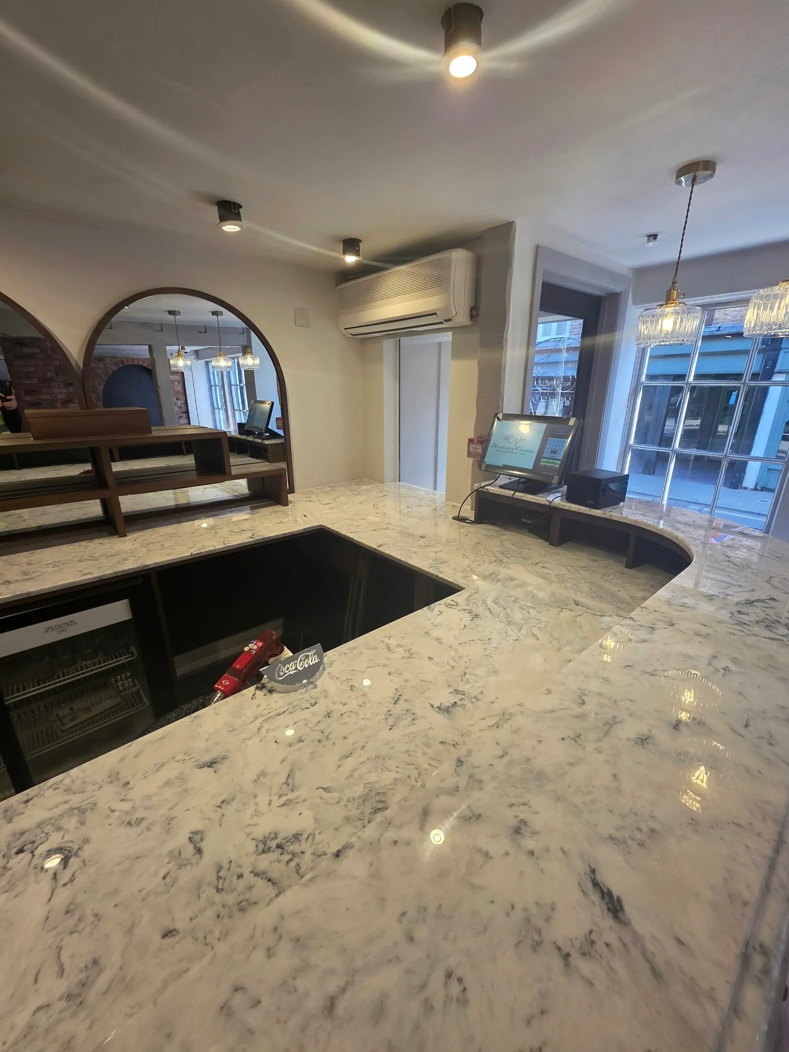Marble bar counter looking towards the arched mirror and front windows