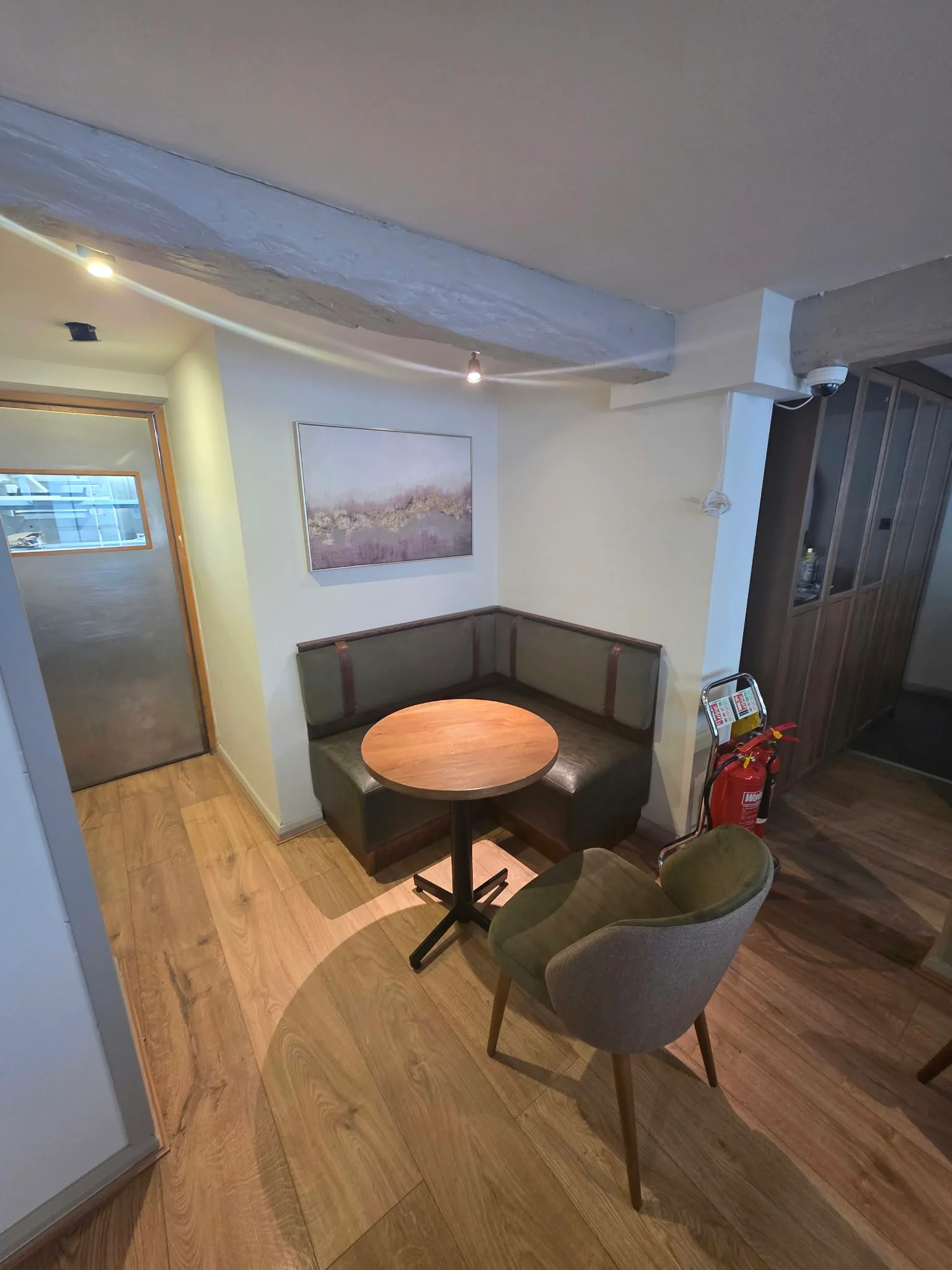 Booth seating with a round timber table and upholstered chairs