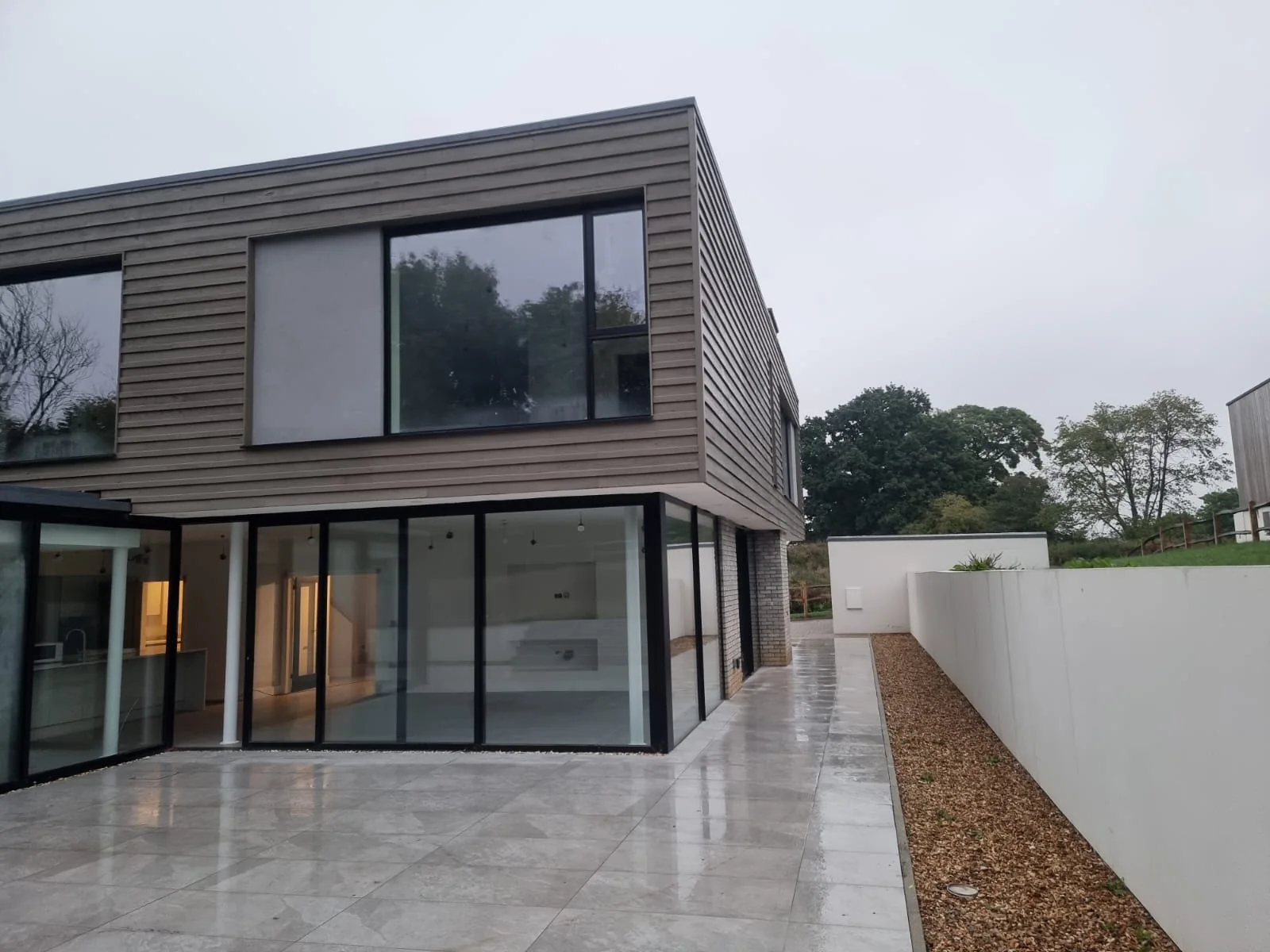Rear elevation with sliding glazing and a rendered garden wall