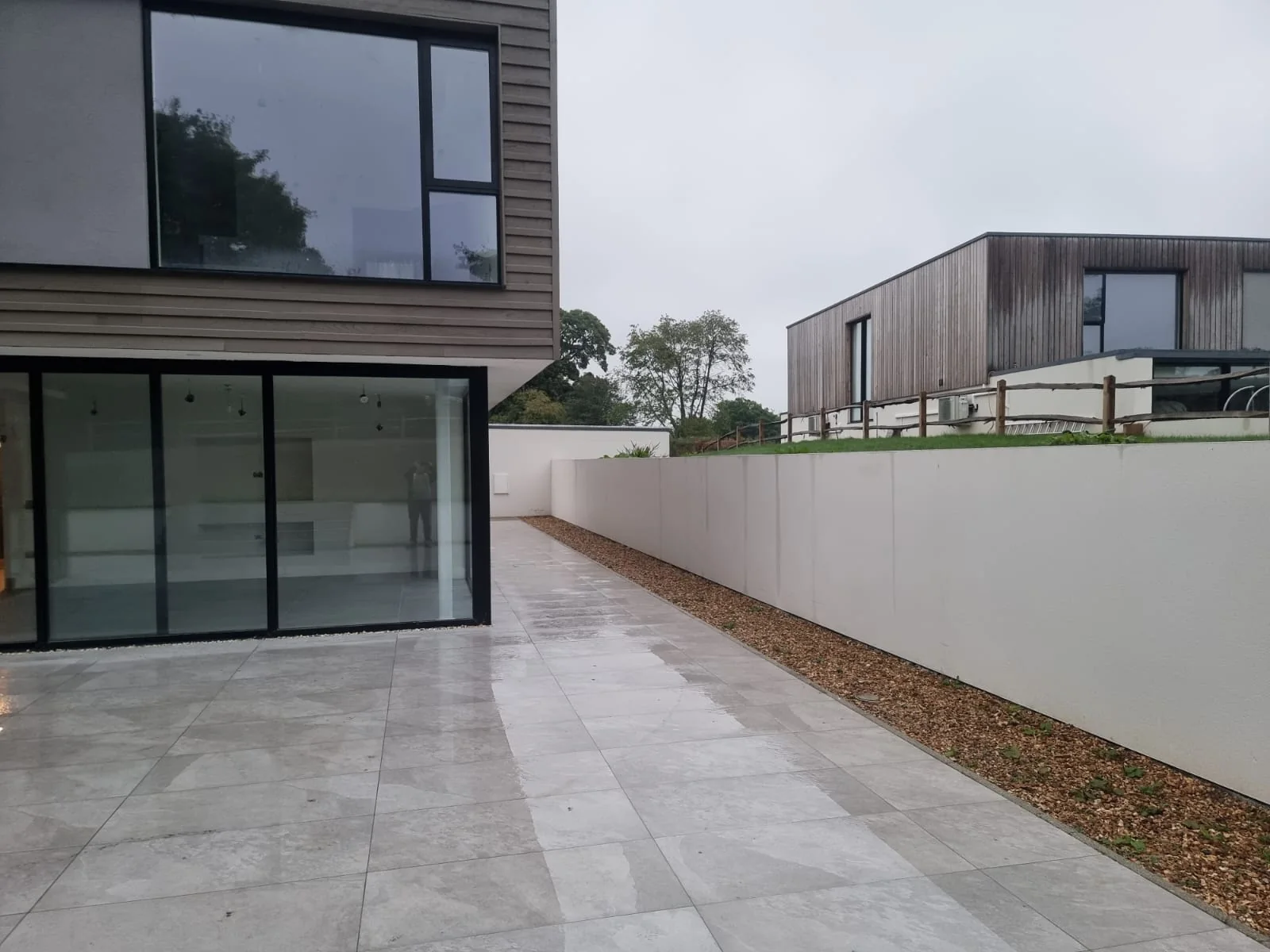 Porcelain-paved side terrace beside the rendered boundary wall