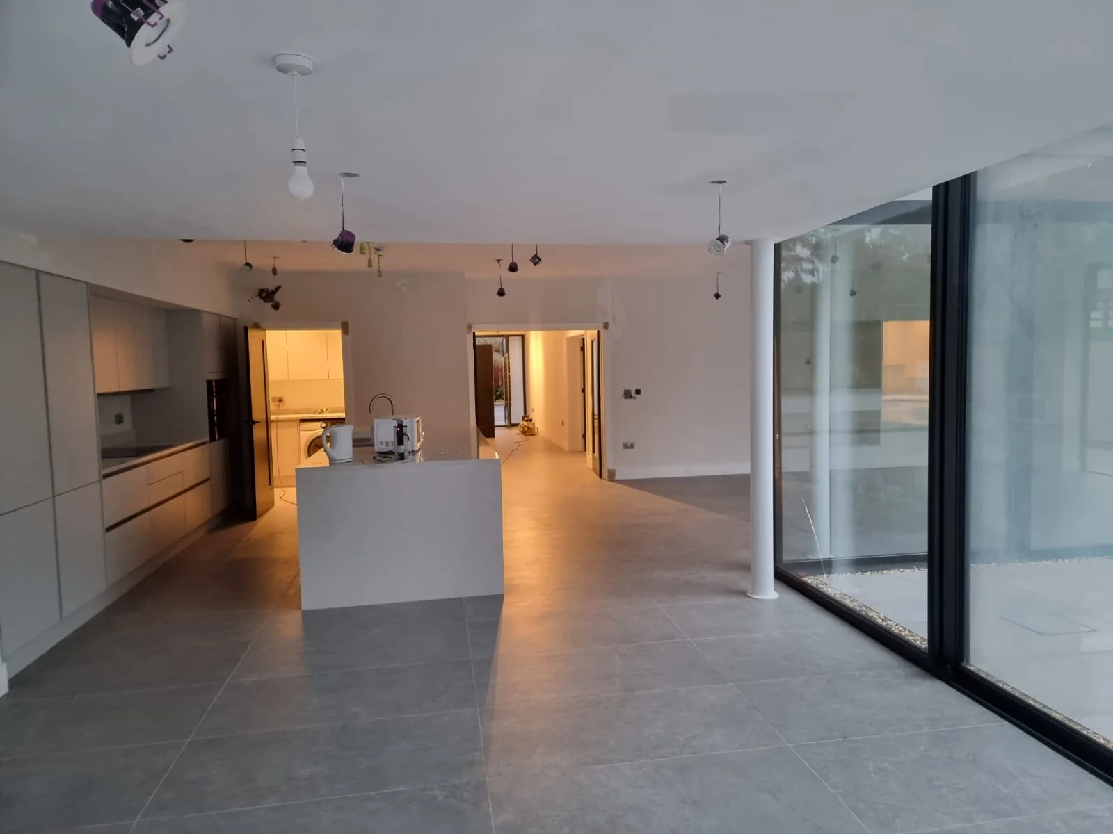Open-plan kitchen with a white island and full-height glazing