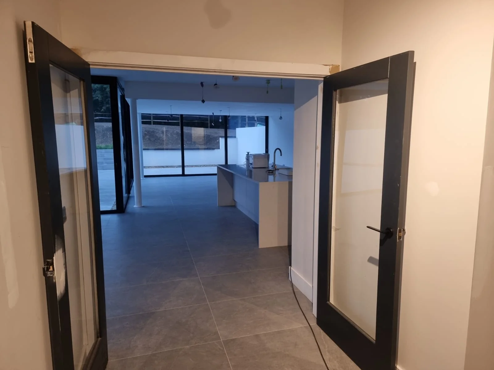 Glazed double doors opening into the open-plan kitchen