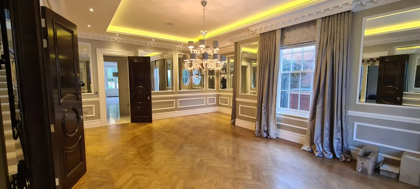 Formal reception room with parquet flooring, panelled walls and a crystal chandelier