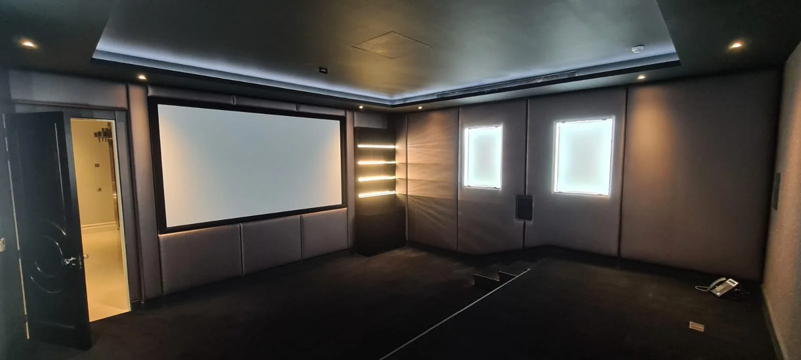 Home cinema room with acoustic wall panels and a large projection screen