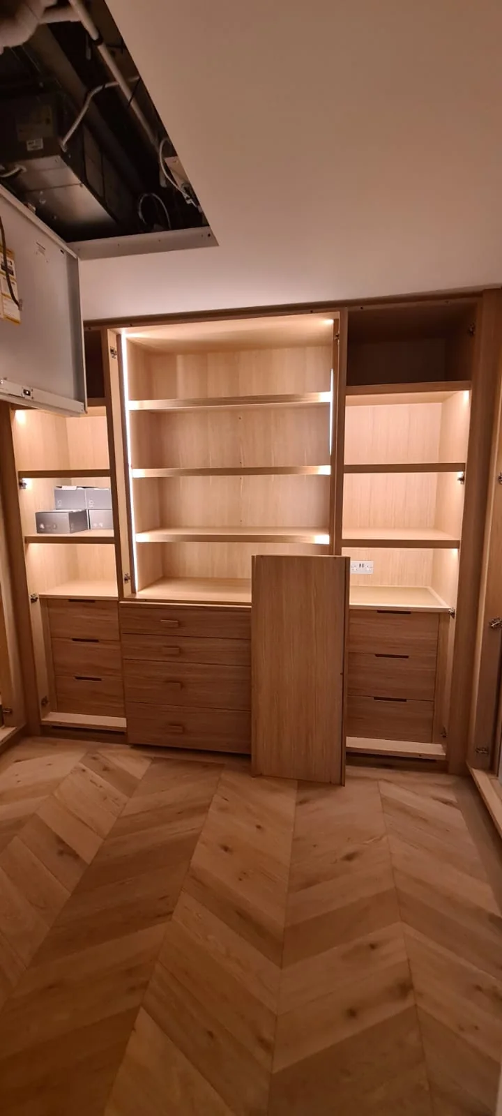 Bespoke oak dressing room joinery with lit shelving and chevron floor