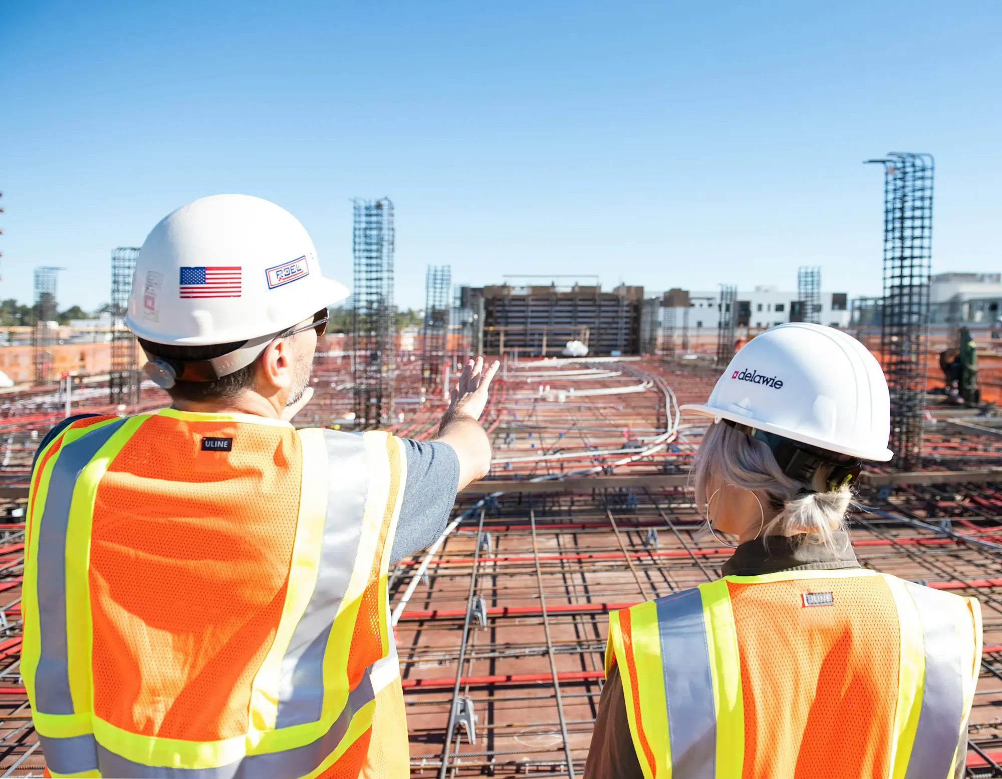 Site managers in hard hats reviewing progress on a construction site (stock image)