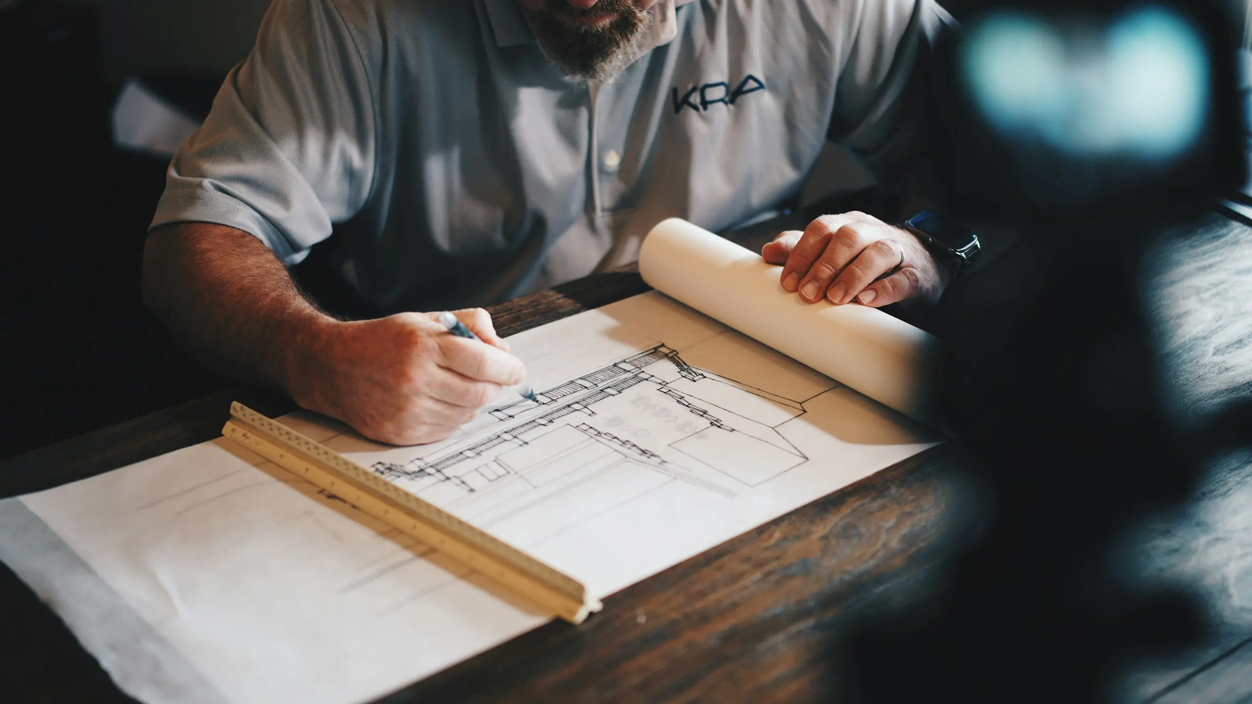 Architect sketching building plans at a desk (stock image)