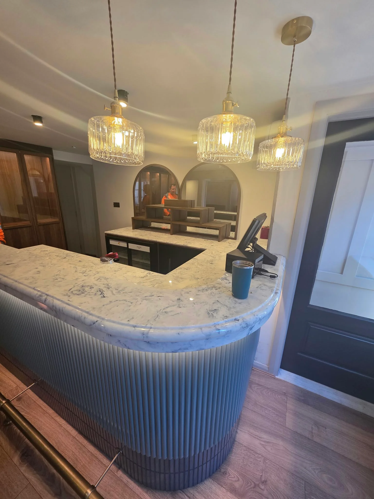Curved marble-topped bar with a fluted front and crystal pendant lights, Heavens Kitchen, Dorking