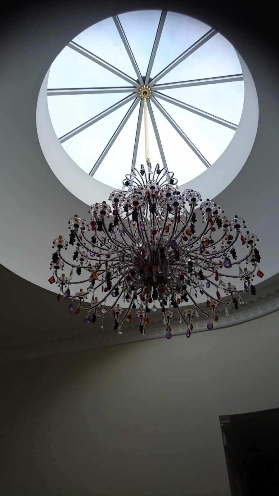 Circular roof lantern above a crystal chandelier