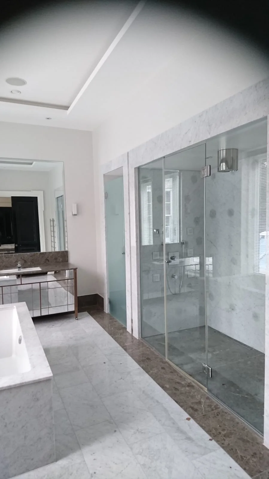 Bathroom with a glass shower enclosure and marble floor