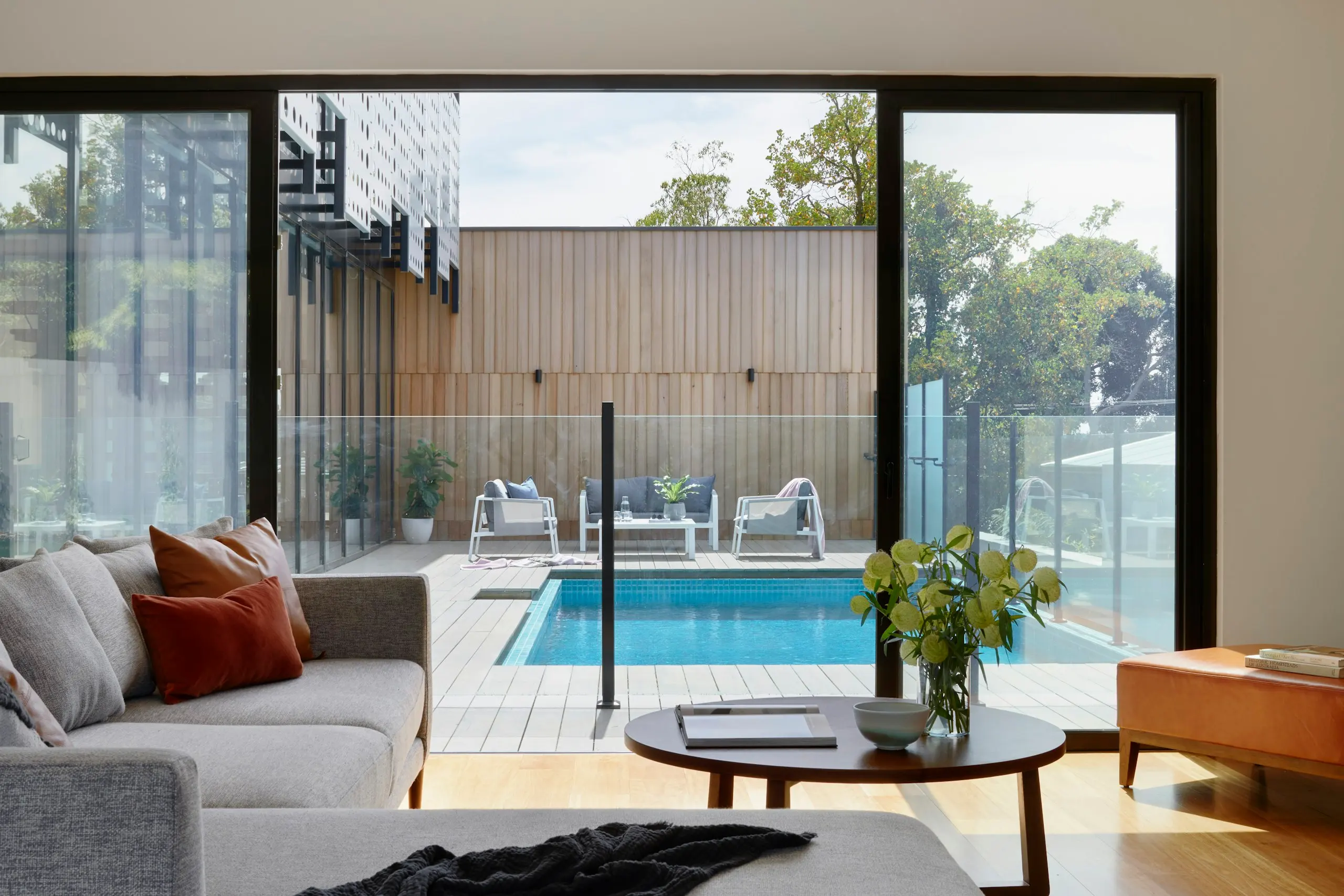 Living room opening through glass doors onto a pool terrace (stock image)